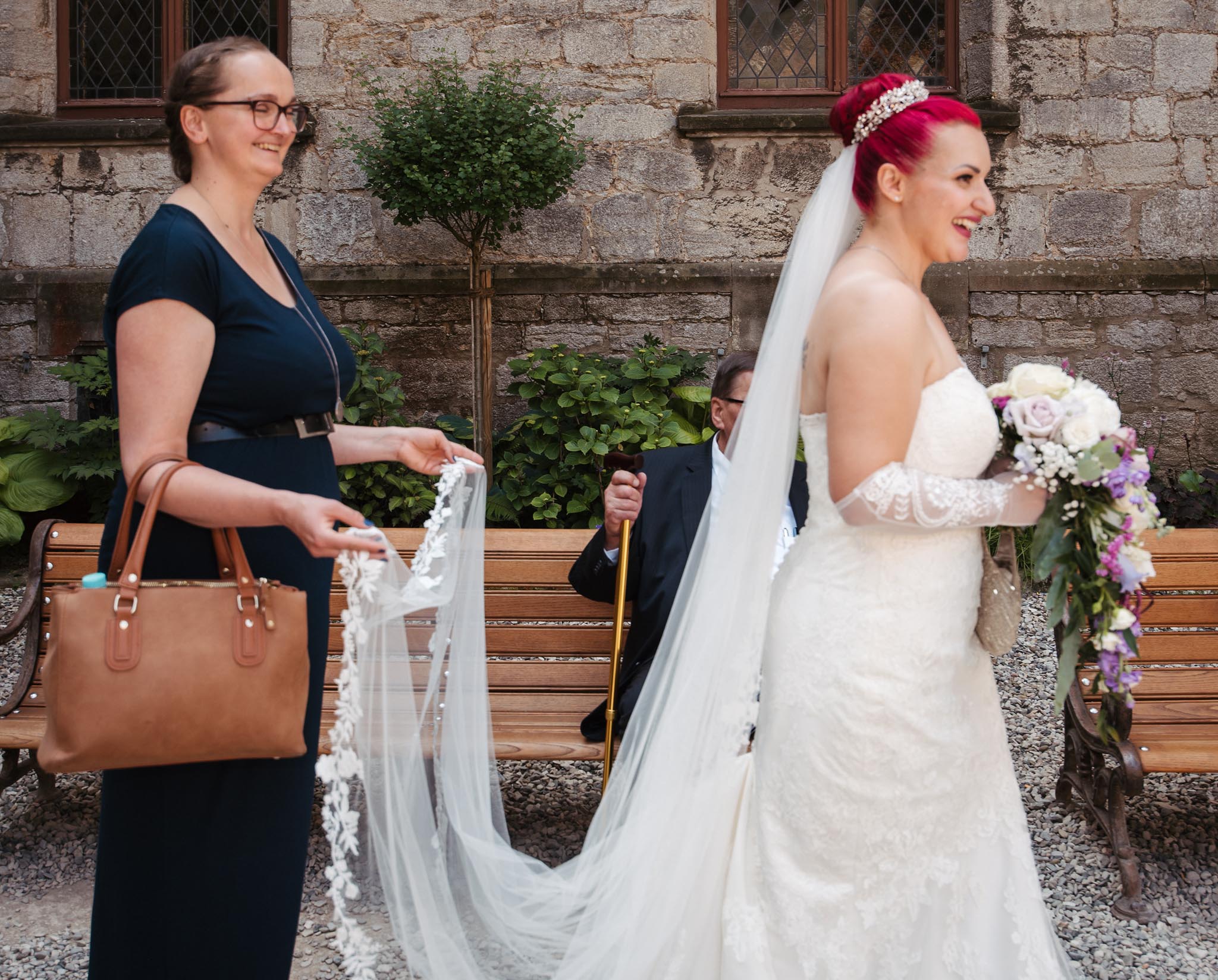 Trauzeugin richtet das Kleid der Braut