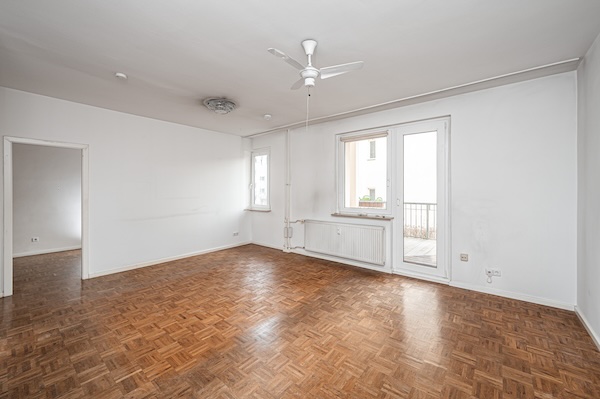 Wohnzimmer mit Eichenparkett und Zugang zum überdachten Balkon in Berlin-Steglitz