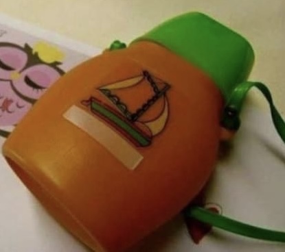 Alte orange grüne Trinkflasche mit Schiff