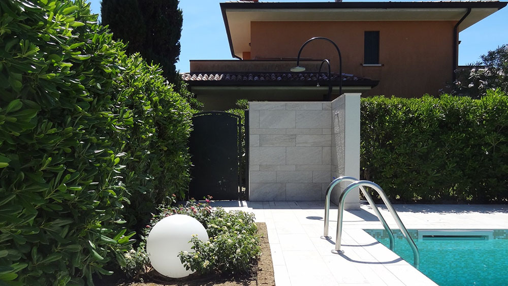 Garten mit einem Pool, eingezäunt und von einer Hecke umgeben.