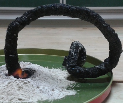 Schwarzer Wurm scheint aus Asche zu kriechen.