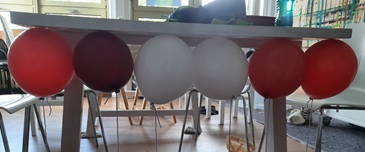 Luftballons schweben an Tischunterseite - statische Elektrizität