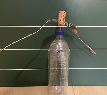Experiment zu Schwerpunkt und Gleichgewicht mit Korken, Gabeln und Stecknadel