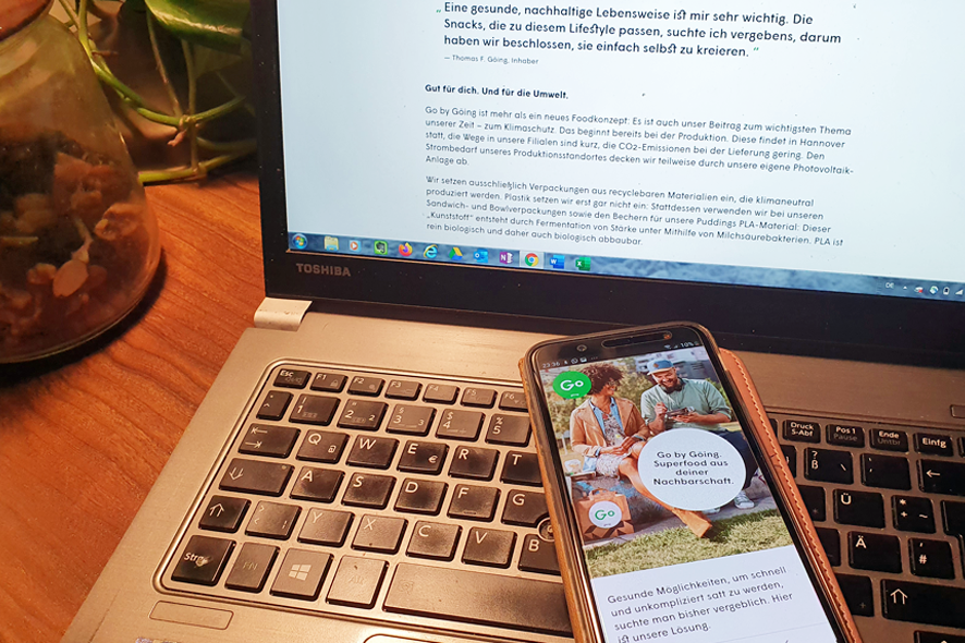 Das Foto zeigt ein Notebook mit daraufliegendem Smartphone, auf dem die (responsive) Webseite von Go. by Göing zu sehen ist