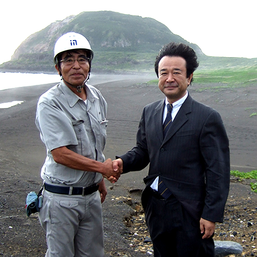 英霊の望郷の島、硫黄島で強風に吹かれ、志を共にする工事事務所長と握手