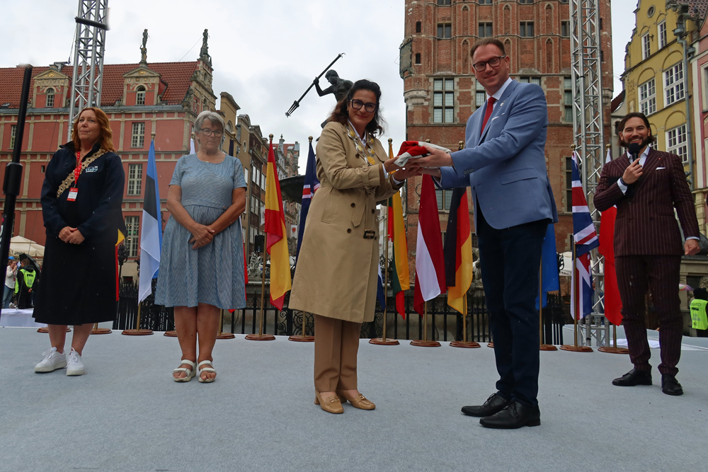 ..Bürgermeisterin Aleksandra Dulkiewicz gibt die Hanseflagge an Jan Lindenau zurück..