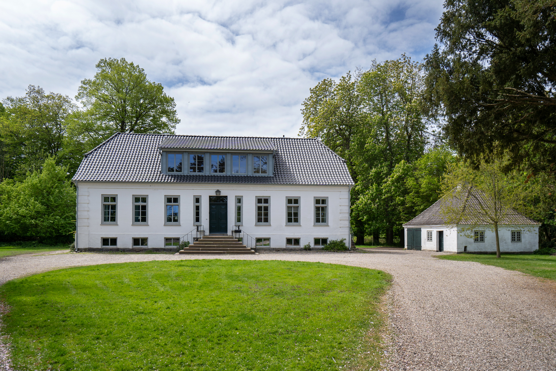 Exklusives Ferienhaus auf Fehmarn: Das imposante Herrenhaus der Familie Thomsen-Detlefs in der Vorderansicht mit gepflegtem Vorgarten.