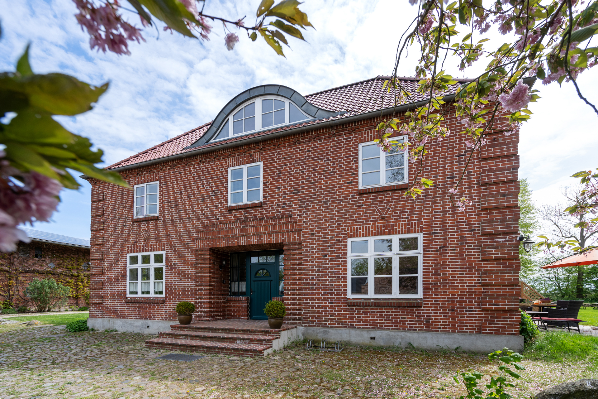 Traditionelles rotes Backsteinhaus von 1920 auf Fehmarn mit gemütlicher Ferienwohnung im Bauernhaus-Stil.