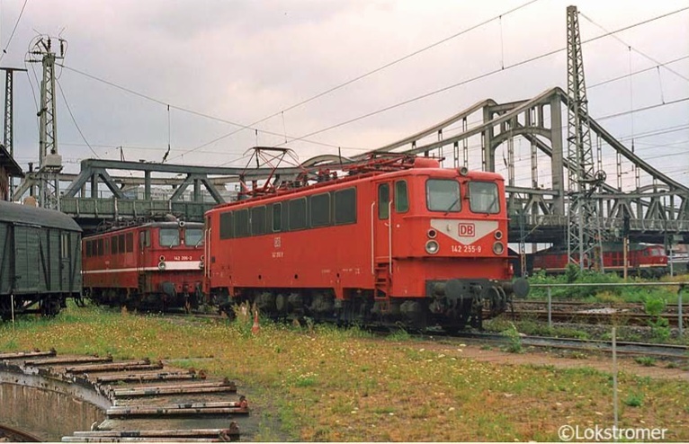 An der Berliner Brücke in Halle/Saale ist viel Betrieb mit DB 142 255 und dahinter 142 206, während im Hintergrund auch noch ein Güterzug mit einer Diesellok der Baureihe 232 die Szenerie passiert. Gesehen am 18.08.1994 vom Gelände des ehemaligen Bw Halle P.