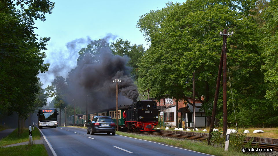 99 4011 mit Personenzug nach Göhren hält in Philippshagen - der Linienbus nach Göhren fährt durch