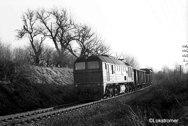 In der Nachmittagssonne des 22.02.1990 fährt DR 120 158 mit einem Güterzug in Richtung Weißenfels bei Prittitz durch die Hügellandschaft.