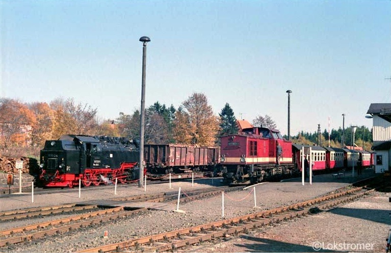 Am 22.10.1989 steht in Benneckenstein DR 199 863 abfahrbereit mit einem Personenzug nach Wernigerode. Daneben rangiert DR 99 7232 mit Holz beladene offene Wagen, um diese später talwärts nach Wernigerode zu fahren.