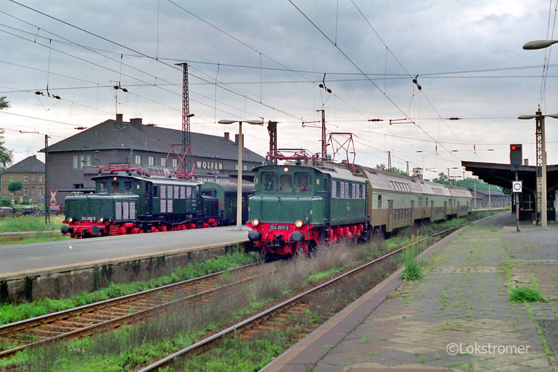 DR 204 001 überholt auf dem Weg von Dessau in Richtung Bitterfeld am 29.06.1991 in Wolfen einen Personenzug mit DR 254 056