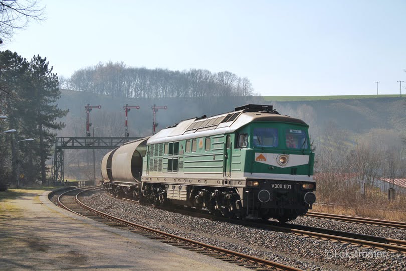 Die Starkenberger V300 001 passiert am 20.03.2015 mit einem Getreidezug aus Richtung Döbeln den Bahnhof Roßwein.