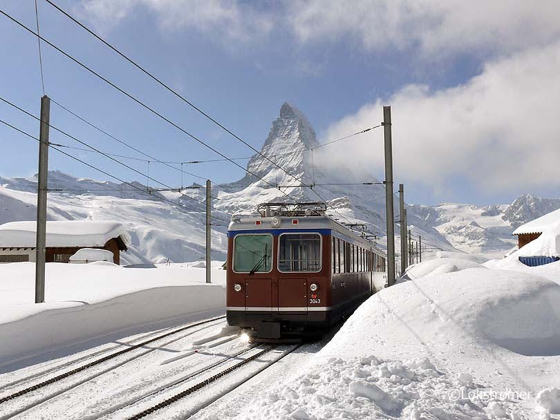 Am 07.03.2009 ist Bhe4/8 3043 der Gornergratbahn an der Station Riffelboden auf dem Weg nach Zermatt. Sehr zur Freude der Passagiere ist klare Sicht auf das Matterhorn 