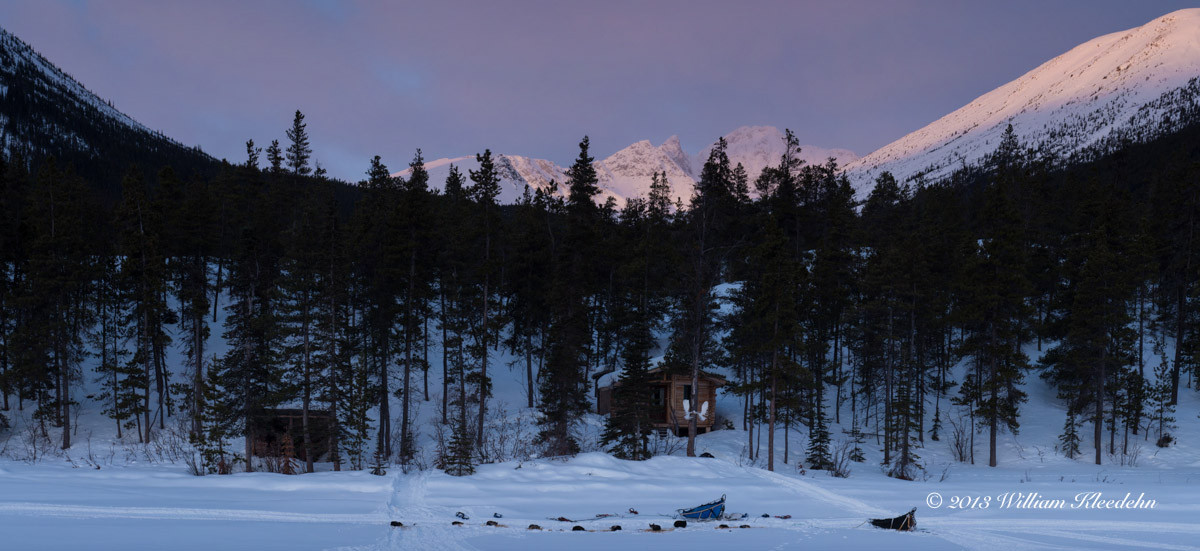 En arrière-plan, une cabane en rondins abandonnée par des américains, qui fut notre refuge pour la nuit. Au premier plan, les chiens et le traîneau. 