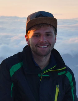 Portraitfoto von Aaron Voderholzer auf einem Berg.
