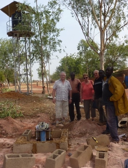 08/12/2015 - P. Michel N'Do fait découvrir le chantier à Jean-Jacques, François et Monique : ici,  la tête du puits, avec en arrière-plan, le château d'eau