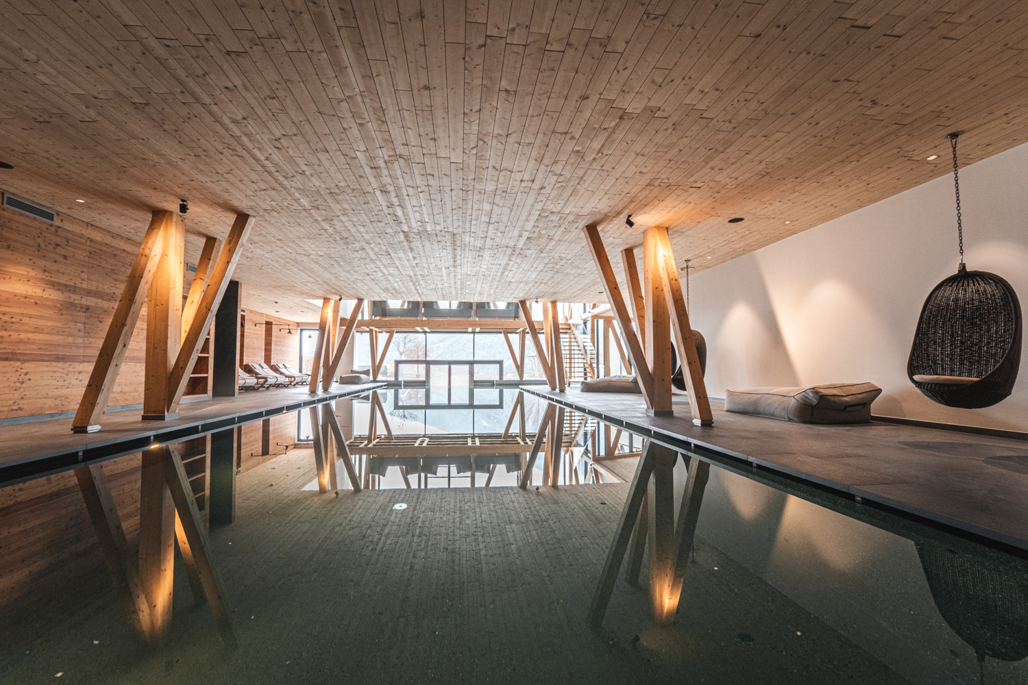A spacious indoor pool area featuring wooden architecture and a tranquil spa atmosphere.