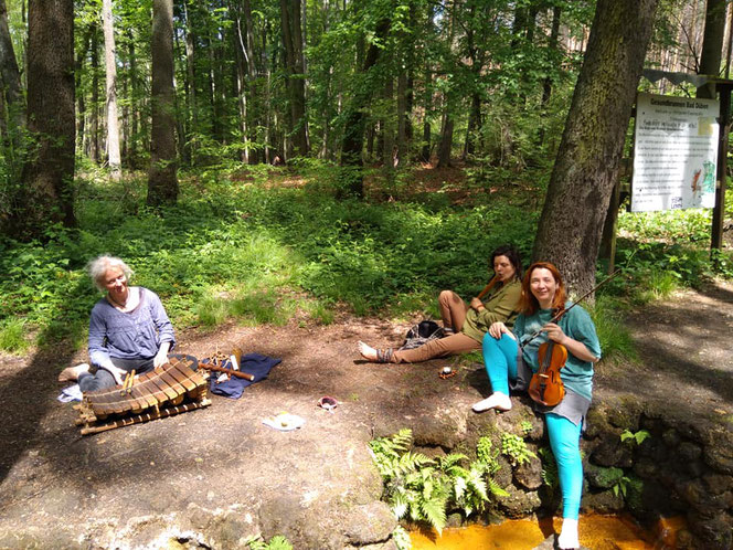 Klangheilung: Drei Menschen mit Instrumenten im Wald