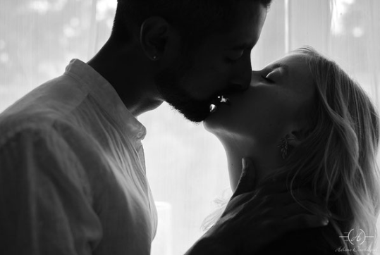 Photo de couple qui s'embrasse avec un baiser de cinéma plein de douceur et de complicité.