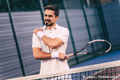 Junger Mann beim Tennis hält sich die Schulter