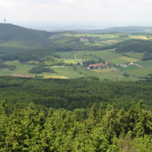 Blick auf die hügelige Landschaft rund um den Gasthof "Zum Hohen Lohr" in Battenhausen mit dem Berg "Hohes Lohr" mit Fernsehturm im Hintergrund; landschaftlich schön gelegen im Naturpark Kellerwald-Edersee in der nordhessischen Grimmheimat