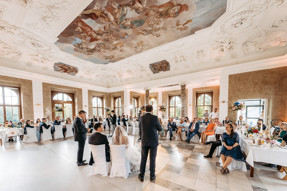 Ein beeindruckendes Weitwinkel-Foto fängt die emotionale Rede des Brautvaters im prunkvollen Saal des Teehauses Altenburg ein.