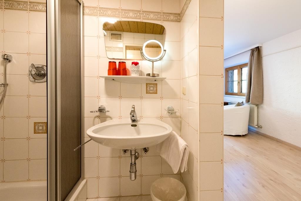 Waschbecken, Fön und Kosmetikspiegel.