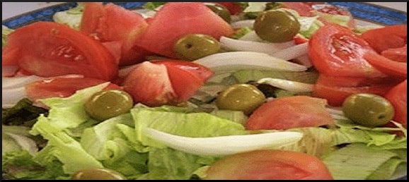 La ensalada valenciana es el acompañamiento sagrado e innegociable de cualquier paella de domingo. Su secreto no es la técnica, sino la calidad extrema de la huerta.