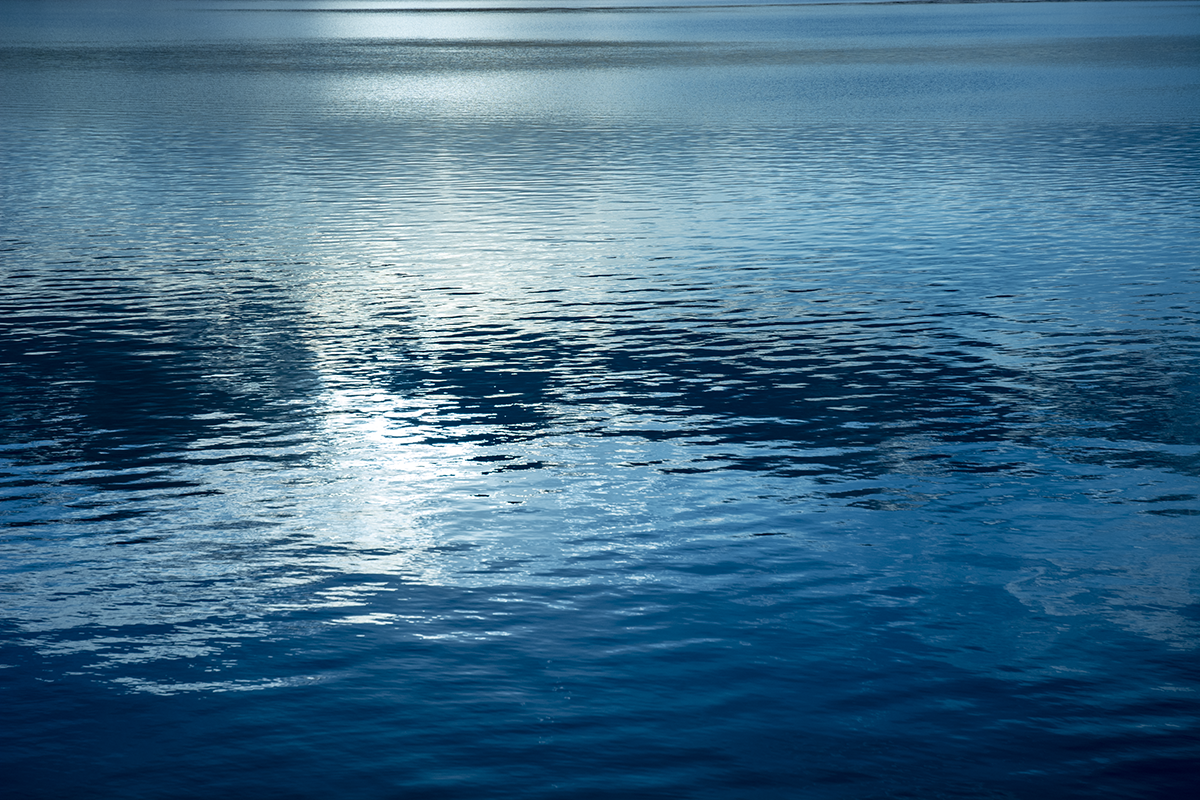 冷たい湖面の青と黒のグラデーション
