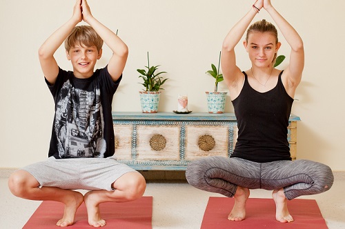 Zwei Jugendliche praktizieren Yoga