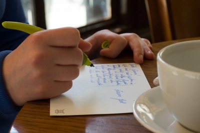 Postkartenschreiben im Café. Symbolbild für Text-Workshops von Laelia Kaderas.