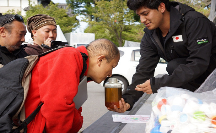 プラスチックからできた油の匂いを嗅ぐリンポチェ