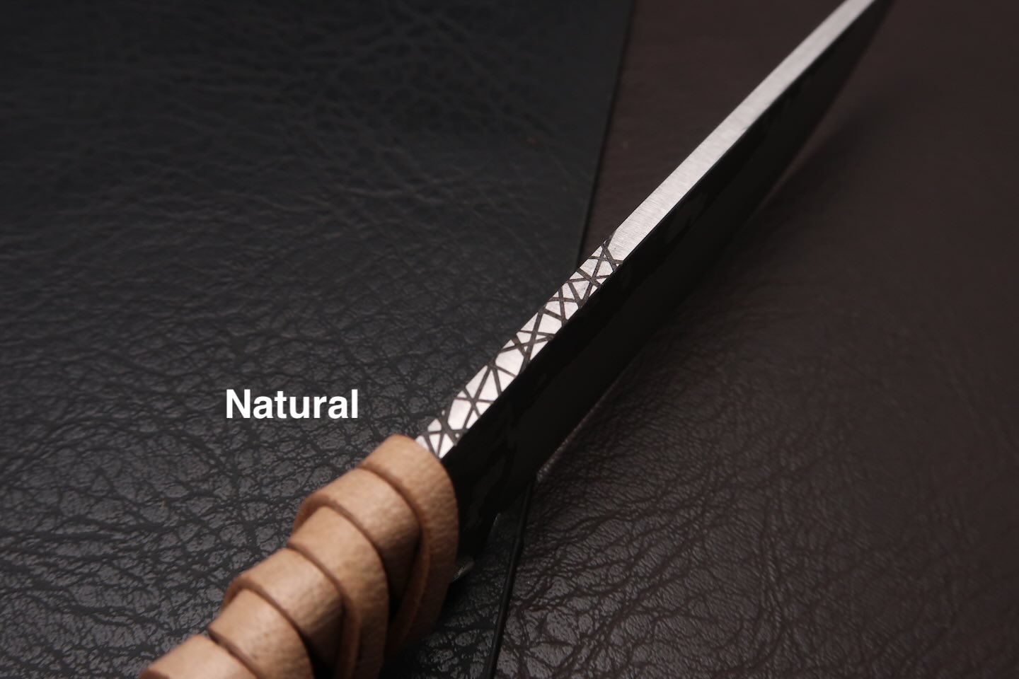 couteau avec un manche en cuir tresse et une ligne de trempe
