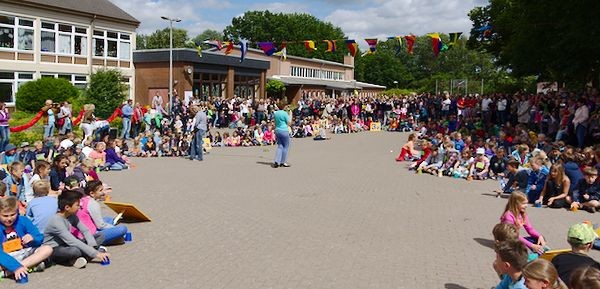 Alle Kinder geben beim Becherrap ihren Becher gleichzeitig weiter.