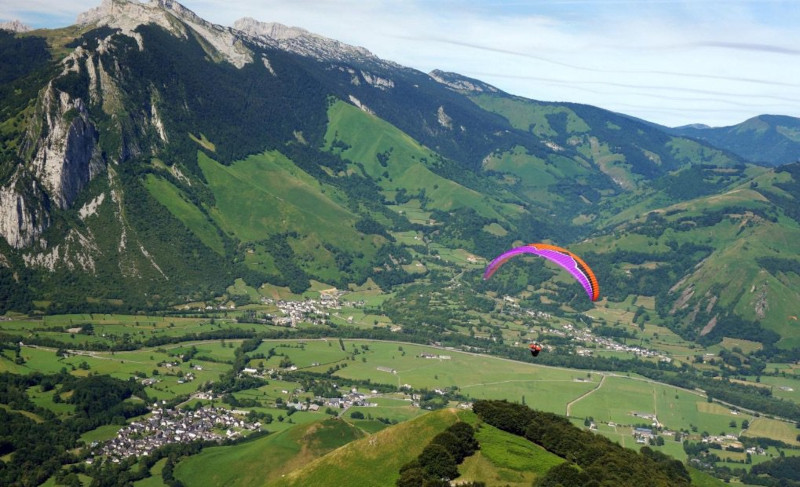 Un parapente survole les sommets de la vallée d'Aspe, dans les Pyrénées. 