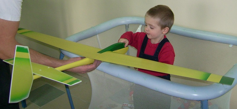 Robert Marechal, pas encore deux ans, admire le planeur coquillaj Coquillaj Aeromod jaune et vert de son papa.