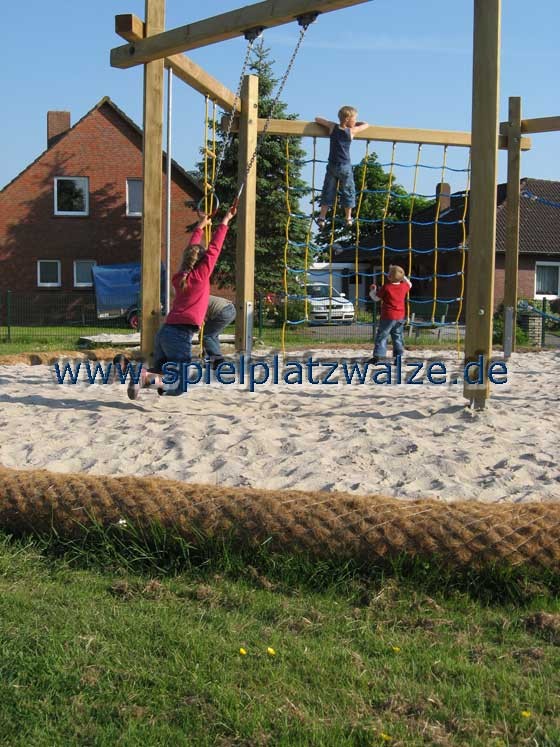 Spielplatzwalzen trennen Rasenfläche und Sandbereich