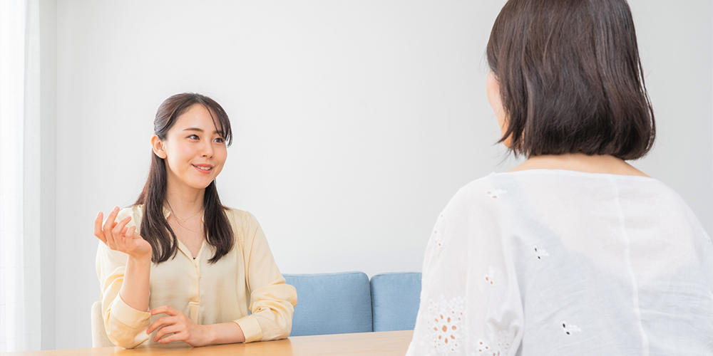 カウンセリングで会話している二人の女声のイメージ写真
