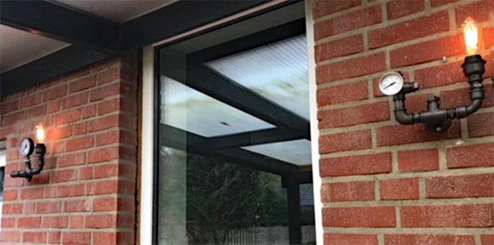 Lampen aus Fittings und schwarzen Stahlrohren im wettergeschützten Außenbereich. Die im Laufe der Zeit entstehende Rost-Patina ist erwünscht. | (c) A. Krienen