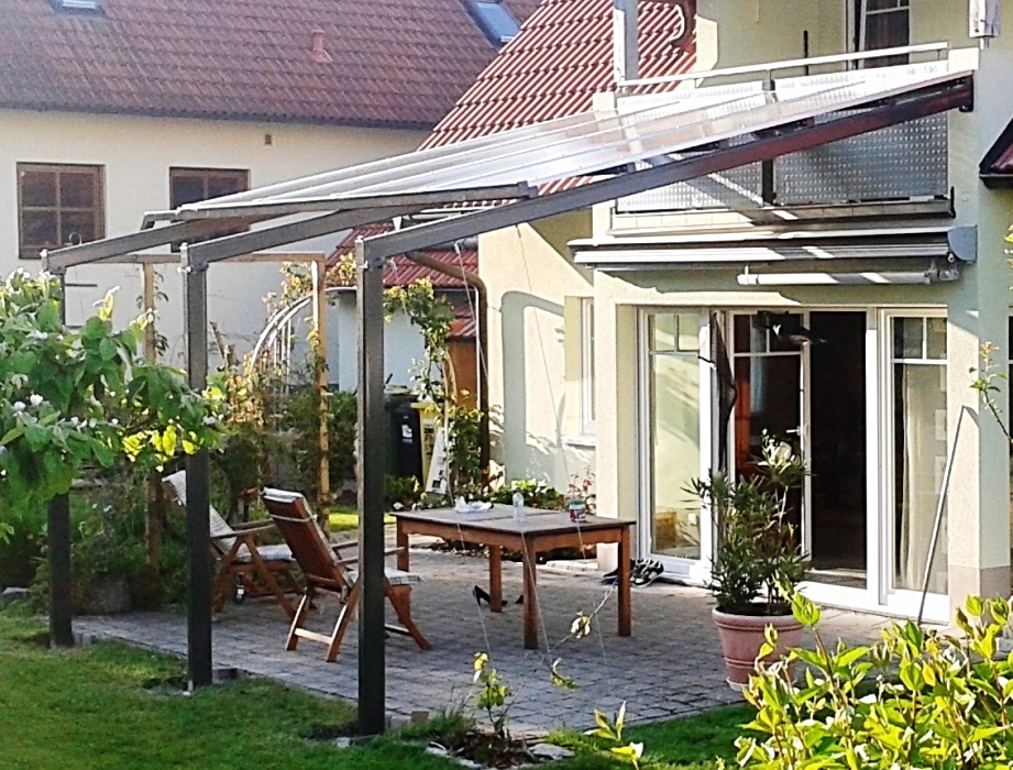 Feuerverzinkte und pulverbeschichtete Terrassenüberdachung mit Heatstop-Doppelstegplatten, integrierter Rinne, Geländer mit Prägeblechen, Edelstahlseilen als Rankhilfe