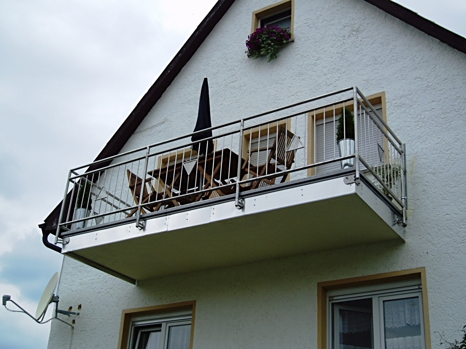 Edelstahlbalkongeländer mit Füllstäben und dreieckigen eingefassten Lochblech-Applikationen