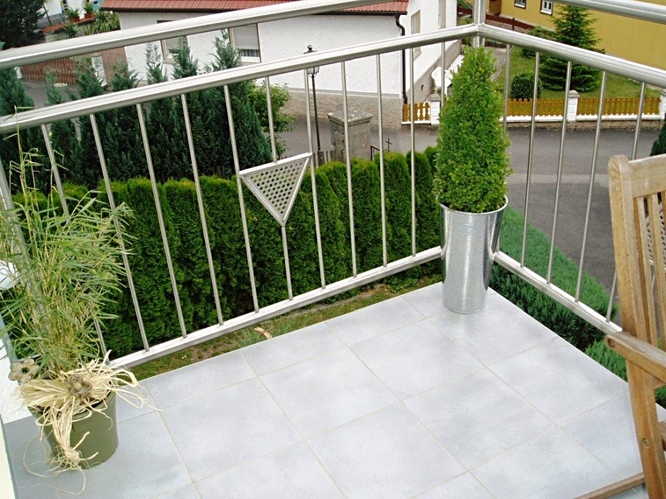 Edelstahlbalkongeländer mit Füllstäben und dreieckigen eingefassten Lochblech-Applikationen