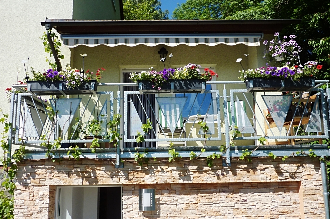 Feuerverzinktes teilschmiedeeisernes Balkongeländer mit Füllstäben, Lochblechen und Blumenkastenhaltern
