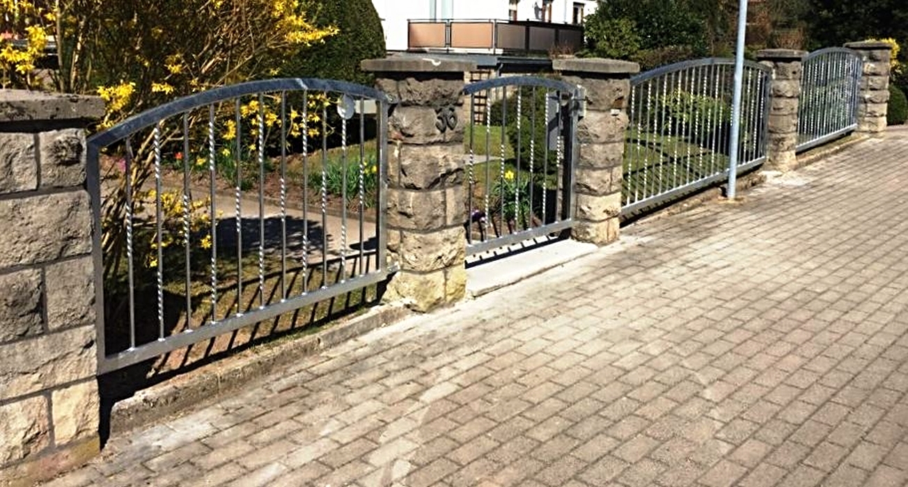 Feuerverzinkter Schmiedeeisenzaun und Tür angepasst an Gefälle und vorhandene Pfosten