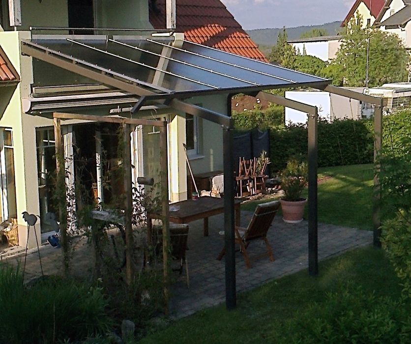 Feuerverzinkte und pulverbeschichtete Terrassenüberdachung mit Heatstop-Doppelstegplatten, integrierter Rinne, Geländer mit Prägeblechen, Edelstahlseilen als Rankhilfe