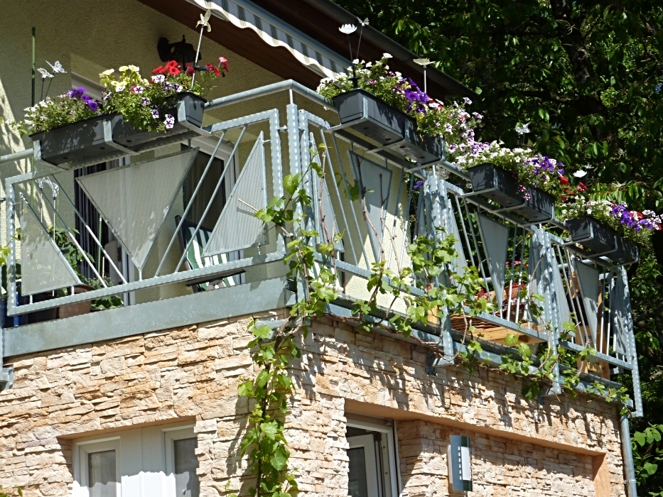 Feuerverzinktes teilschmiedeeisernes Balkongeländer mit Füllstäben, Lochblechen und Blumenkastenhaltern