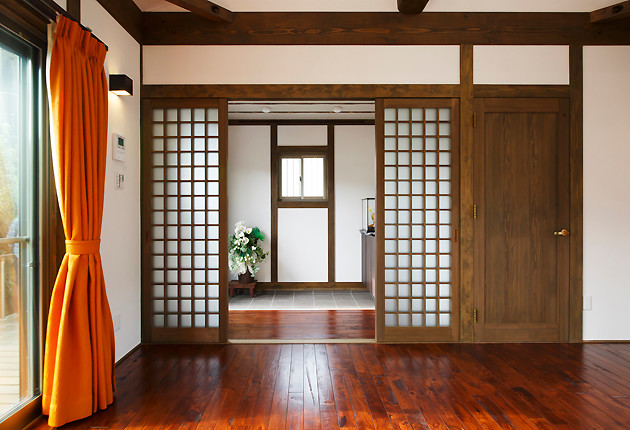 リビングから玄関をみる。整然とした佇まいに格子の建具が趣を加える。