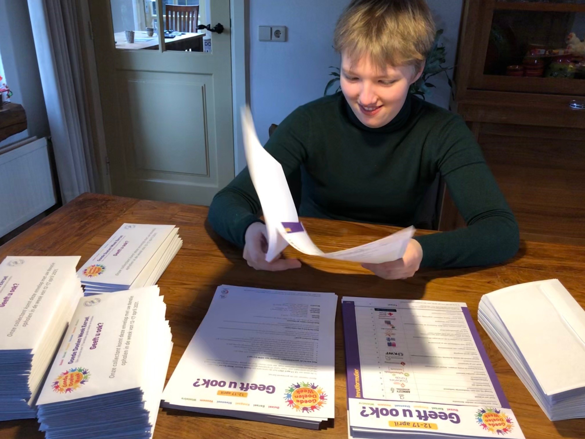 Cliënt Groote Aard sorteert de enveloppen met inhoud